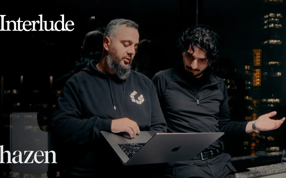 Ahmed Khanji and a Hazen host looking at a laptop together, from the Interlude episode “I asked a Cybersecurity CEO to hack me”.
